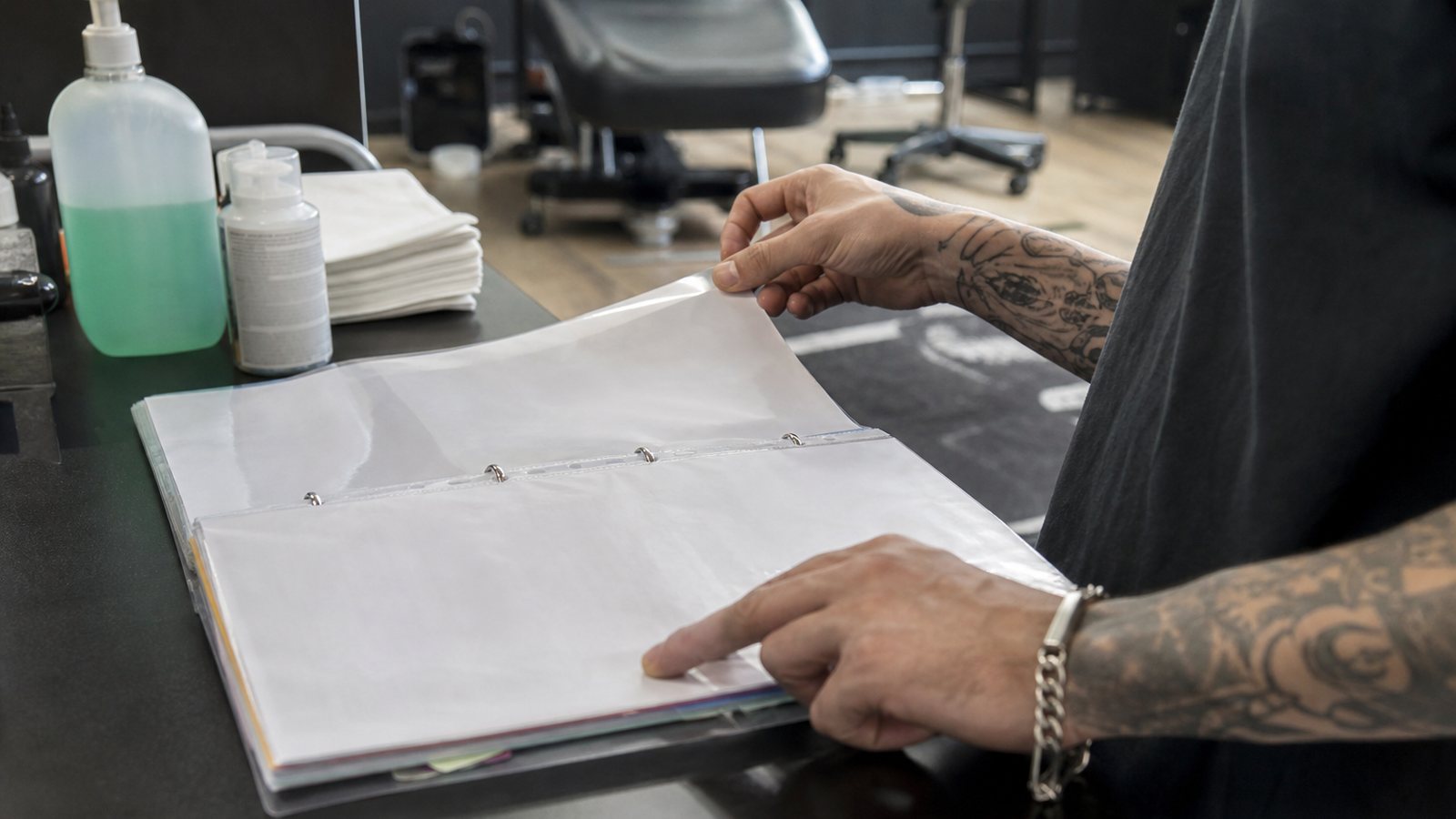 Tatoueur renseignant son registre d'hygiène sur une tablette au studio