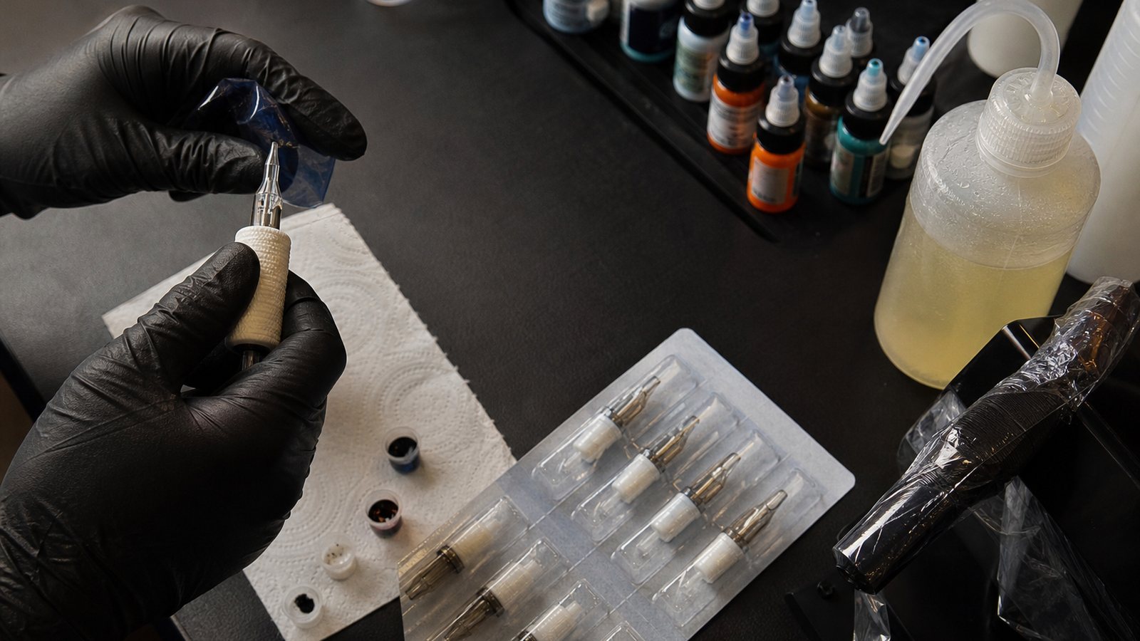 Aiguilles emballées et flacons d'encre étiquetés sur la table d'un tatoueur